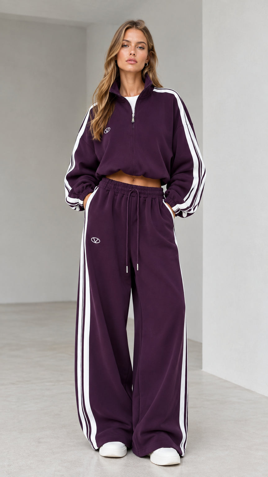 Front view of woman wearing deep plum cropped quarter-zip tracksuit set with side stripes