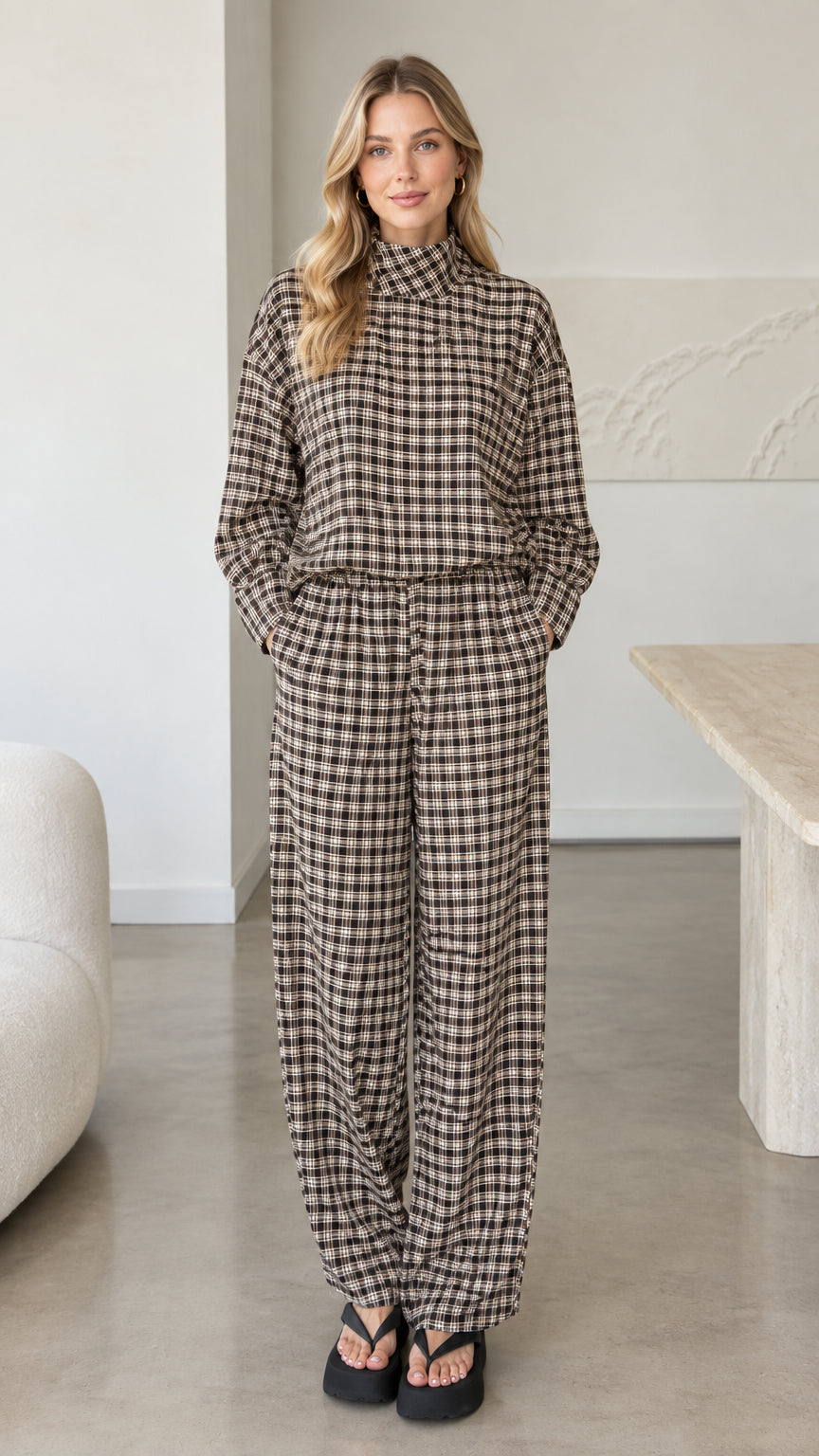 Front view of woman wearing brown plaid mock neck top and wide leg pants set