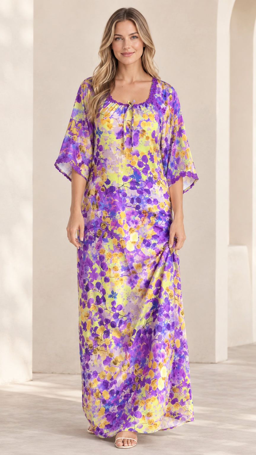 Front view of model wearing purple and yellow floral kaftan maxi dress with crochet lace neckline