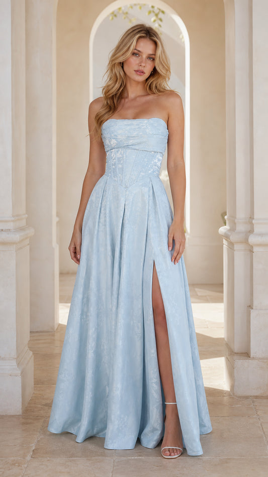 Front view of model in light blue strapless jacquard corset gown with high slit