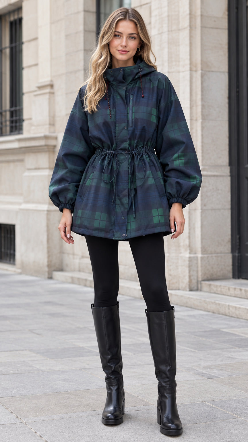 Front view of woman wearing navy green plaid hooded drawstring parka jacket with black boots
