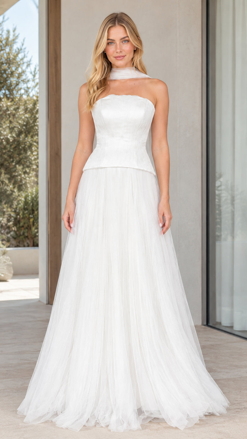 Front view of model wearing strapless white peplum corset tulle evening gown with neck scarf