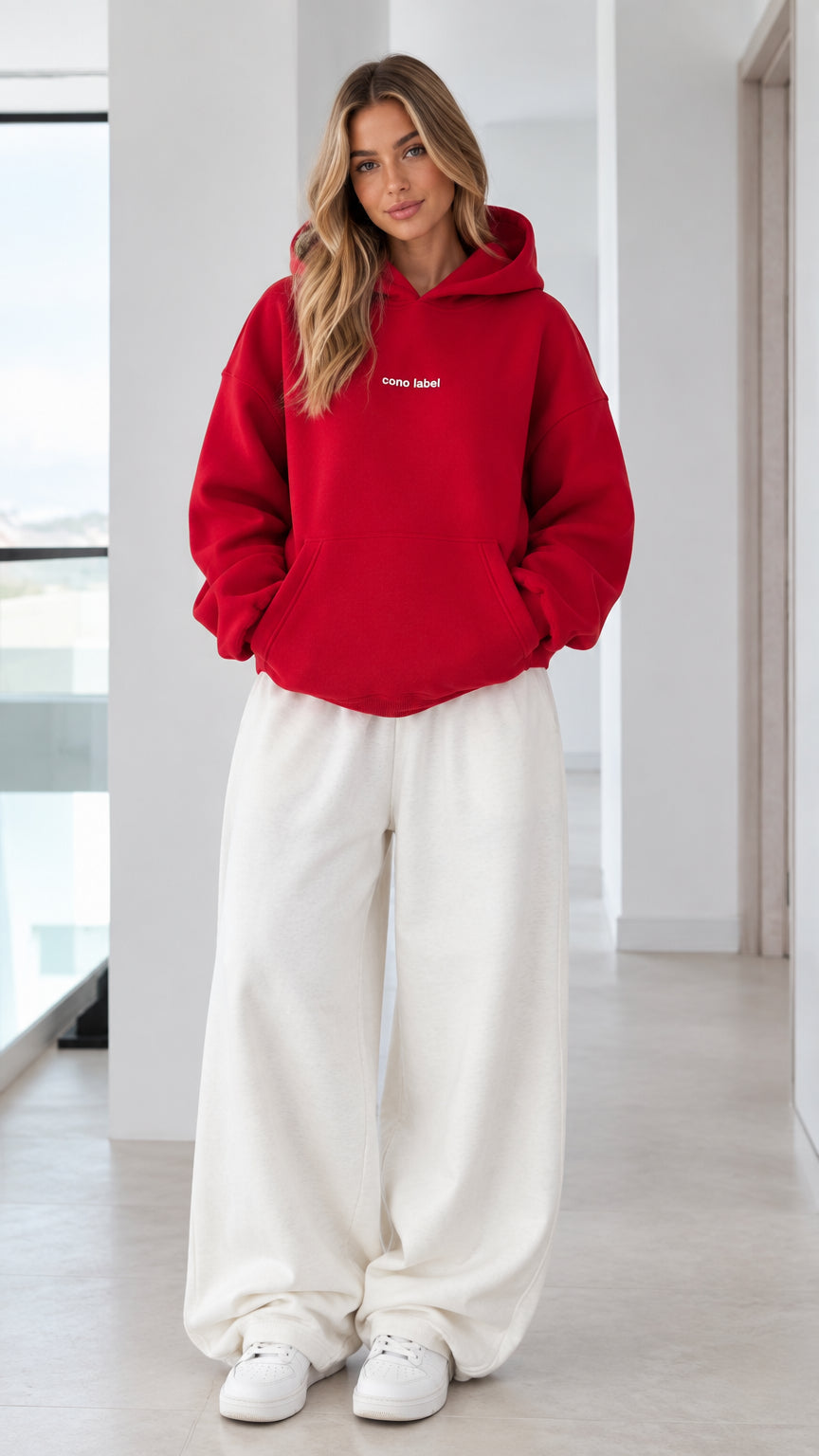 Women's oversized red pullover hoodie paired with white wide-leg sweatpants - front view