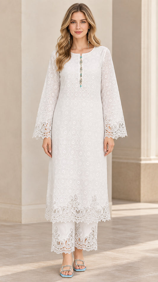 Front view of woman wearing white eyelet embroidered long tunic and matching lace-trimmed pants set