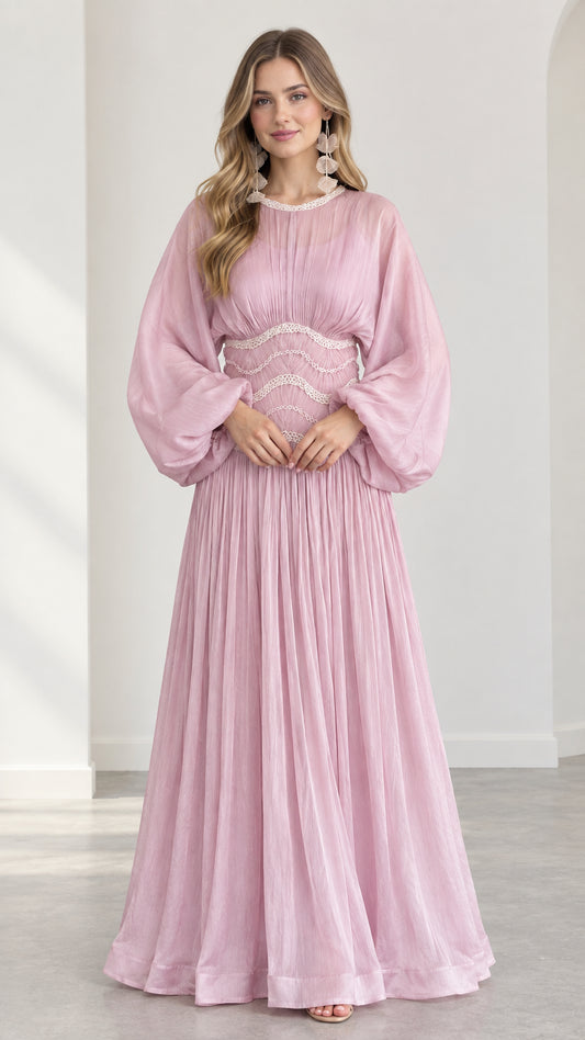 Front view of model wearing pink pleated maxi dress with balloon sleeves and embroidered waist