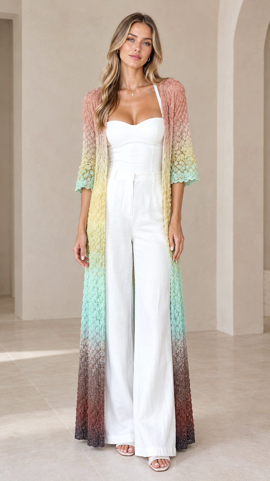 Front view of woman wearing Pastel Multi gradient crochet maxi duster cardigan over a white jumpsuit