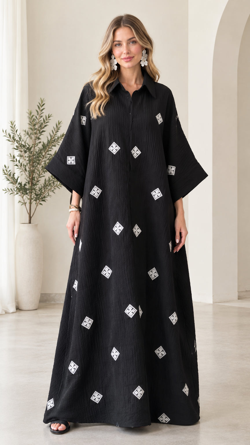 Front full-length view of model wearing black embroidered crinkle maxi shirt dress