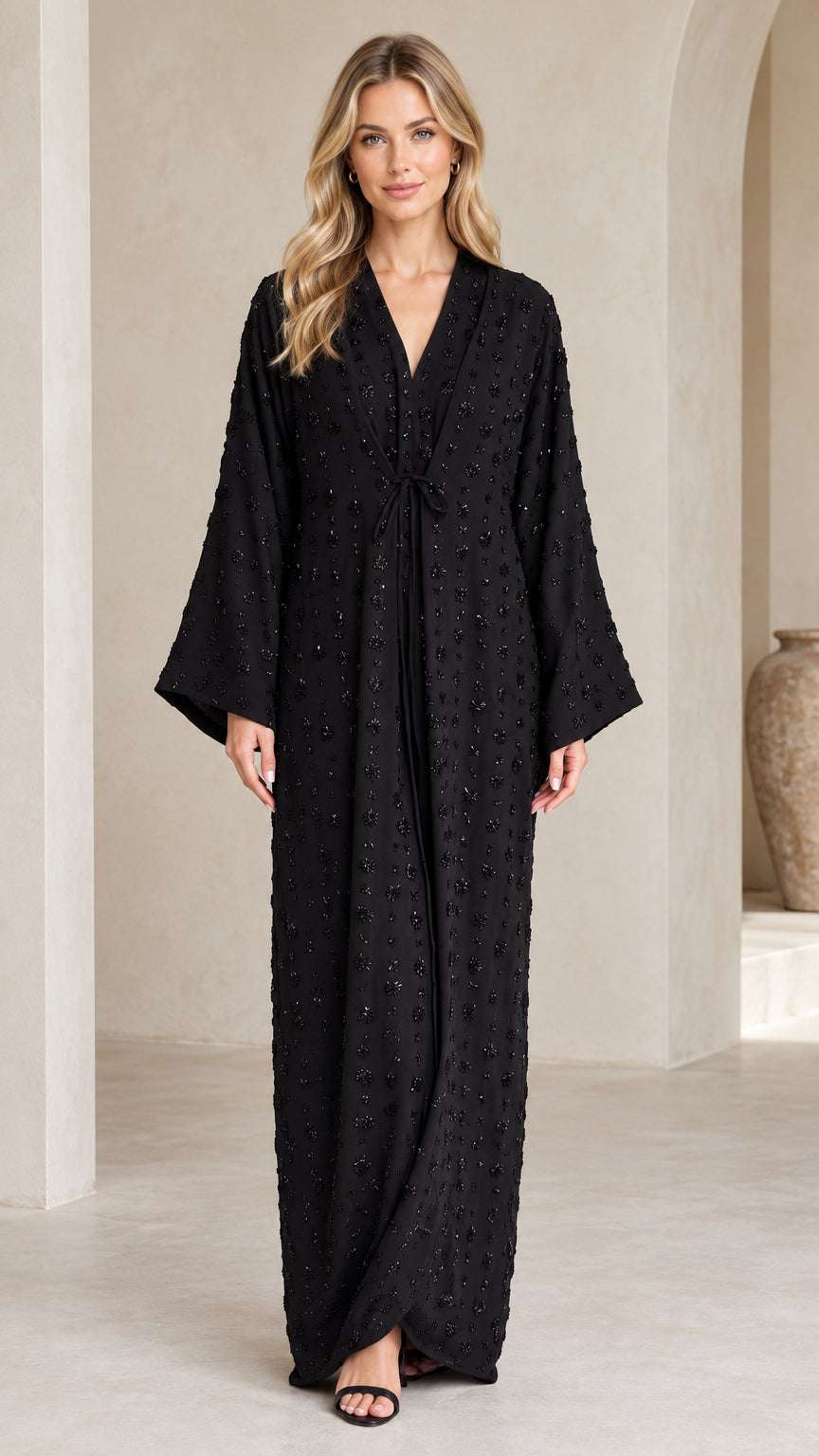 Front full-length view of woman wearing Black floral embellished abaya maxi dress with tie waist