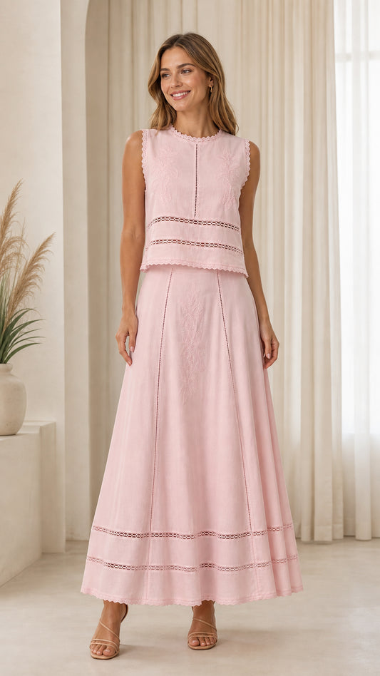 Front view of woman wearing pink embroidered sleeveless top and maxi skirt set