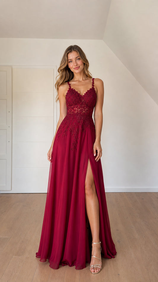 Front view of woman wearing burgundy lace applique A-line chiffon formal gown with leg slit