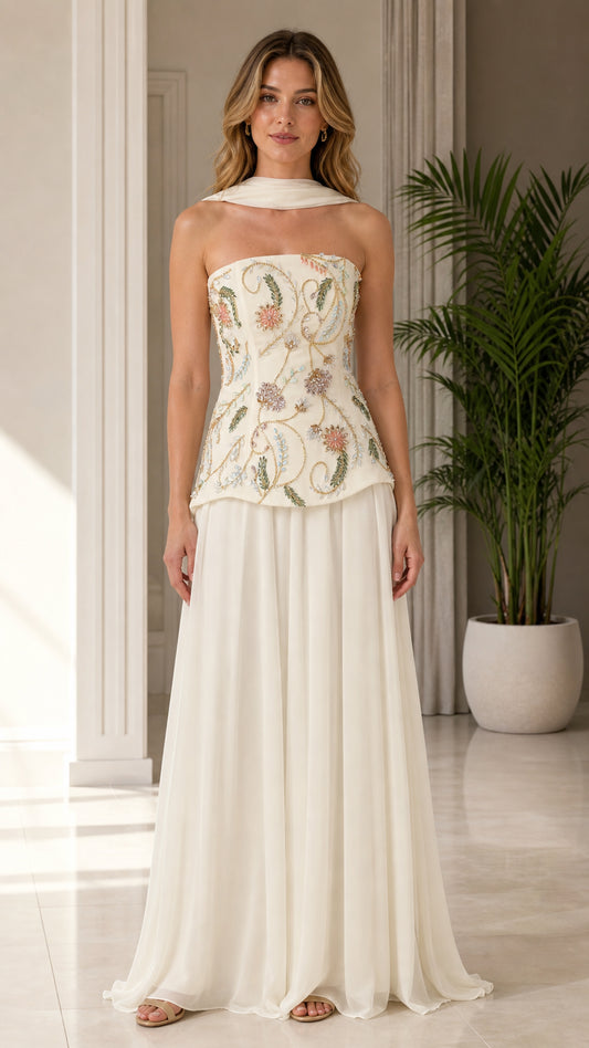 Front view of model wearing ivory strapless beaded floral corset evening gown with scarf