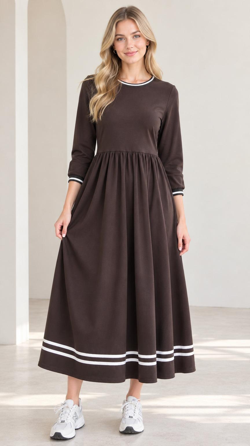 Front view of woman wearing brown 3/4 sleeve maxi dress with white striped trim
