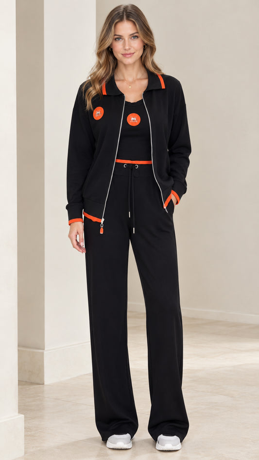 Front view of model wearing black 3-piece tracksuit set with orange trim