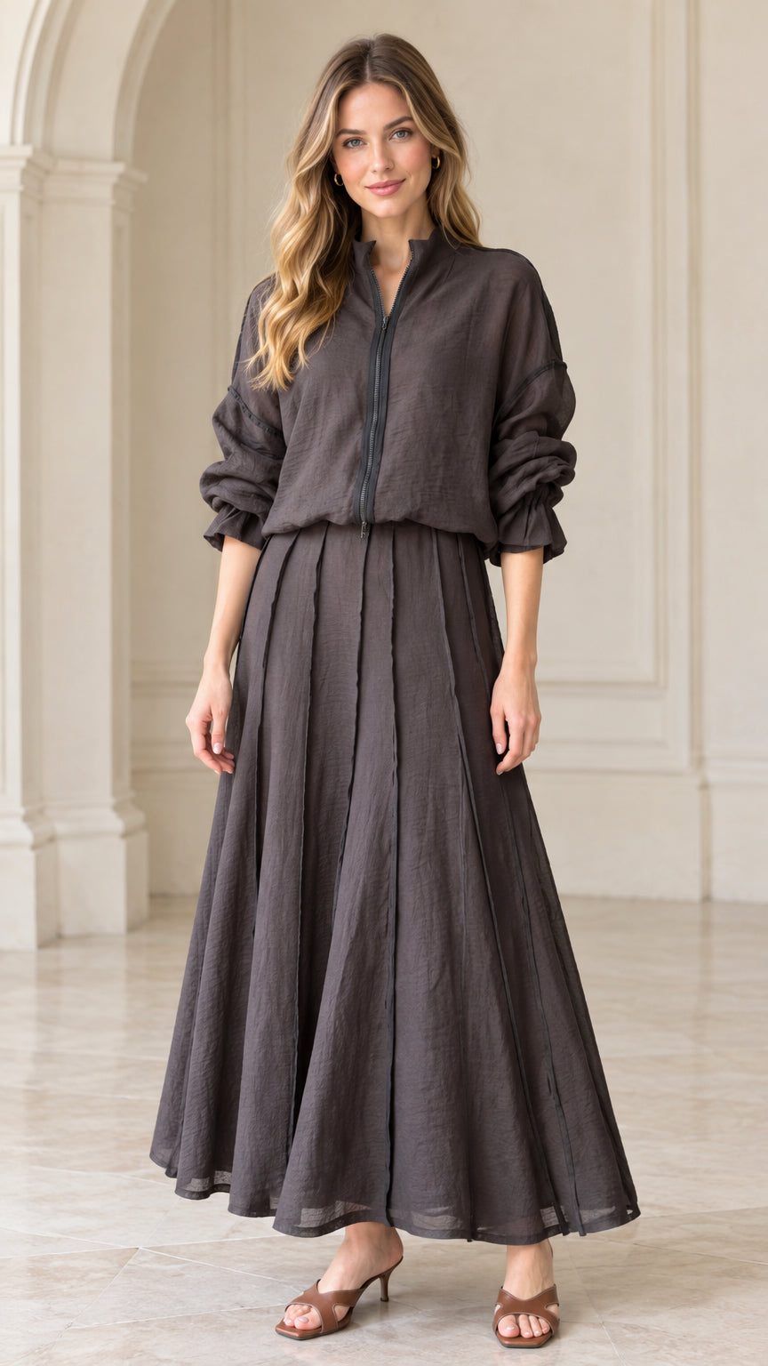 Front view of woman wearing charcoal grey textured zip-front top and pleated maxi skirt set