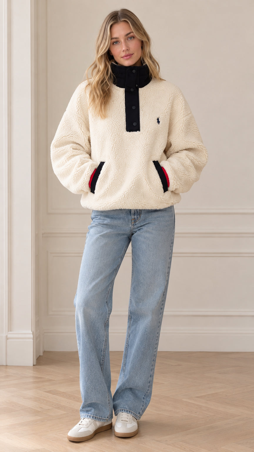 Front view of model wearing cream sherpa fleece snap-neck pullover with light blue jeans