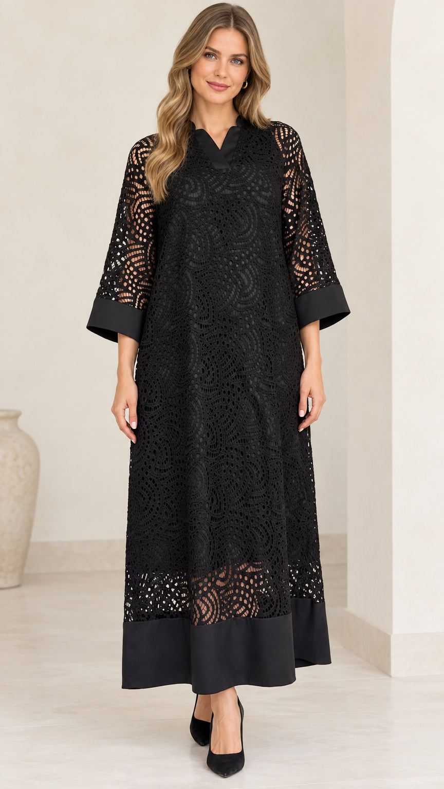 Front view of model wearing black lace overlay maxi dress with solid trim