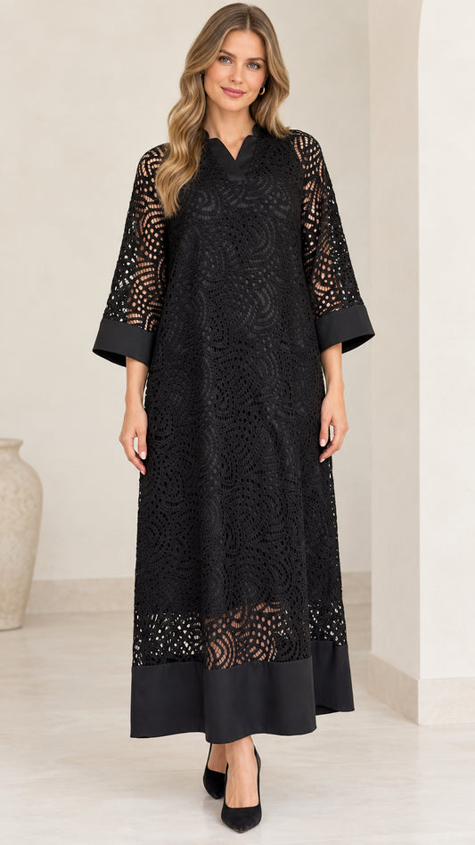 Front view of model wearing black lace overlay maxi dress with solid trim