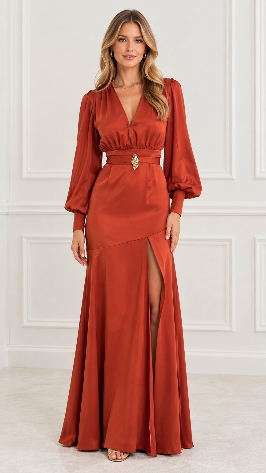 Front view of model wearing a rust orange satin long sleeve maxi evening gown with high slit