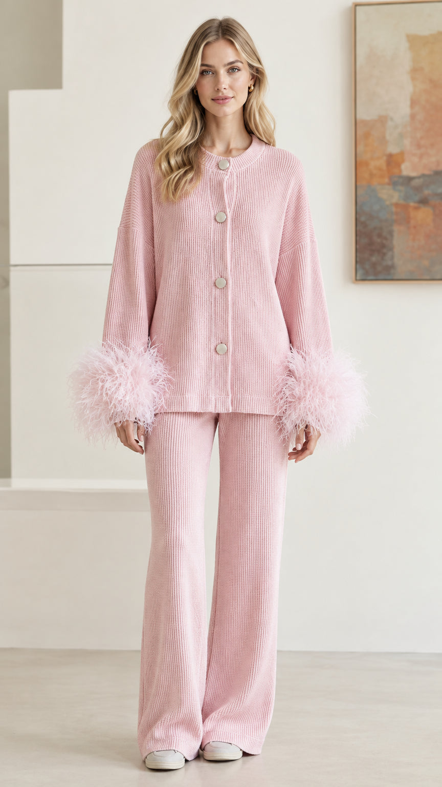 Front full view of woman wearing pastel pink ribbed knit two-piece set with feather cuffs