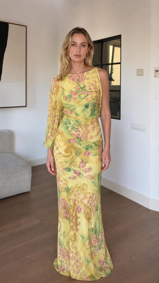Front view of woman wearing yellow floral one-sleeve maxi dress