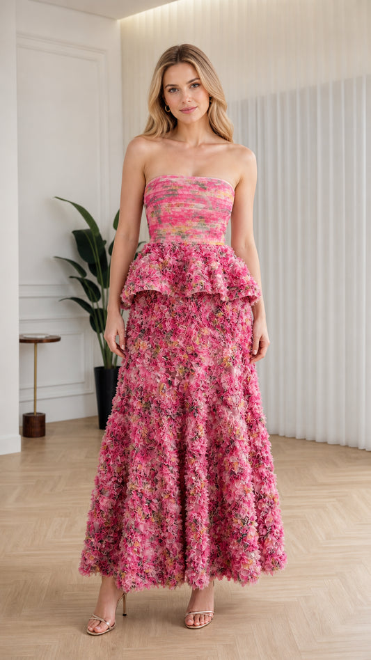 Front view of model wearing pink strapless floral ruffle peplum maxi dress