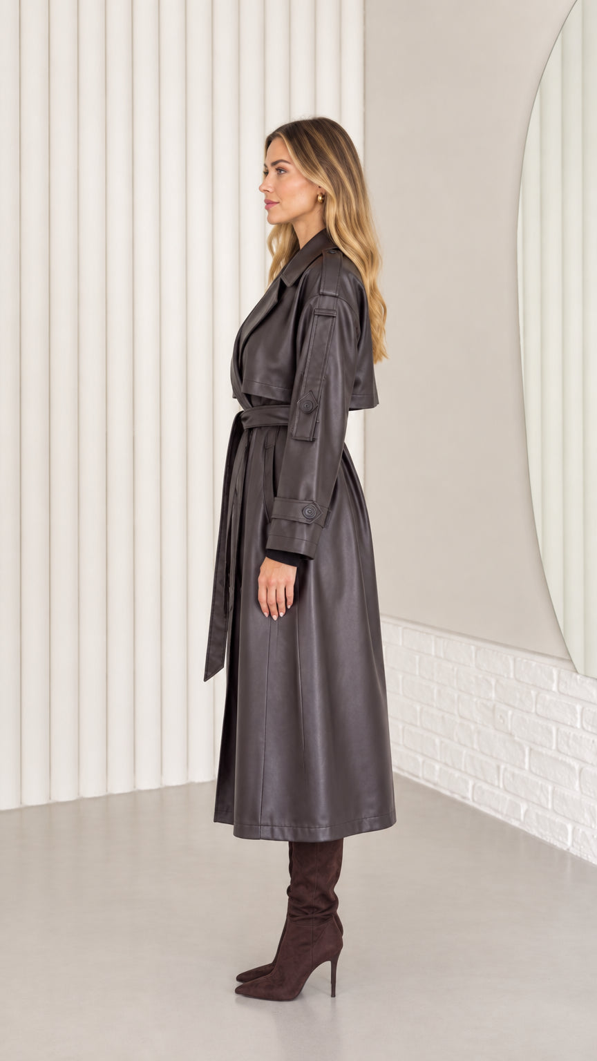 Side profile view of dark brown faux leather long trench coat with waist tie