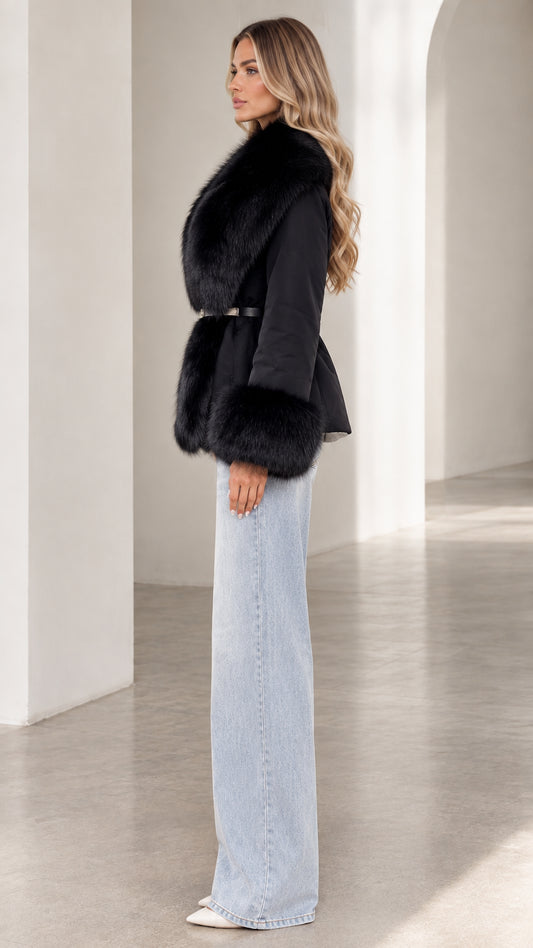 Side profile view of model wearing black faux fur belted coat with wide-leg denim