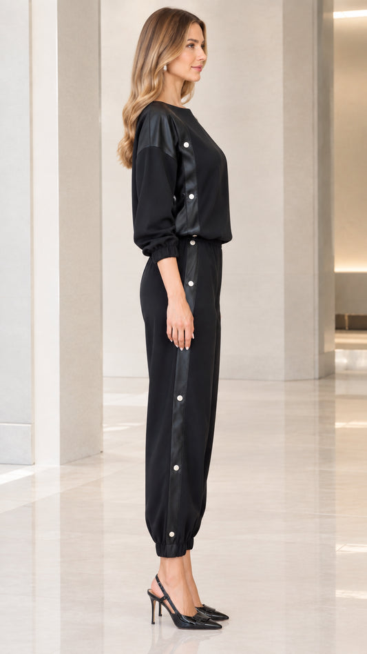 Side profile view showing snap button accents along black sweatshirt and pants