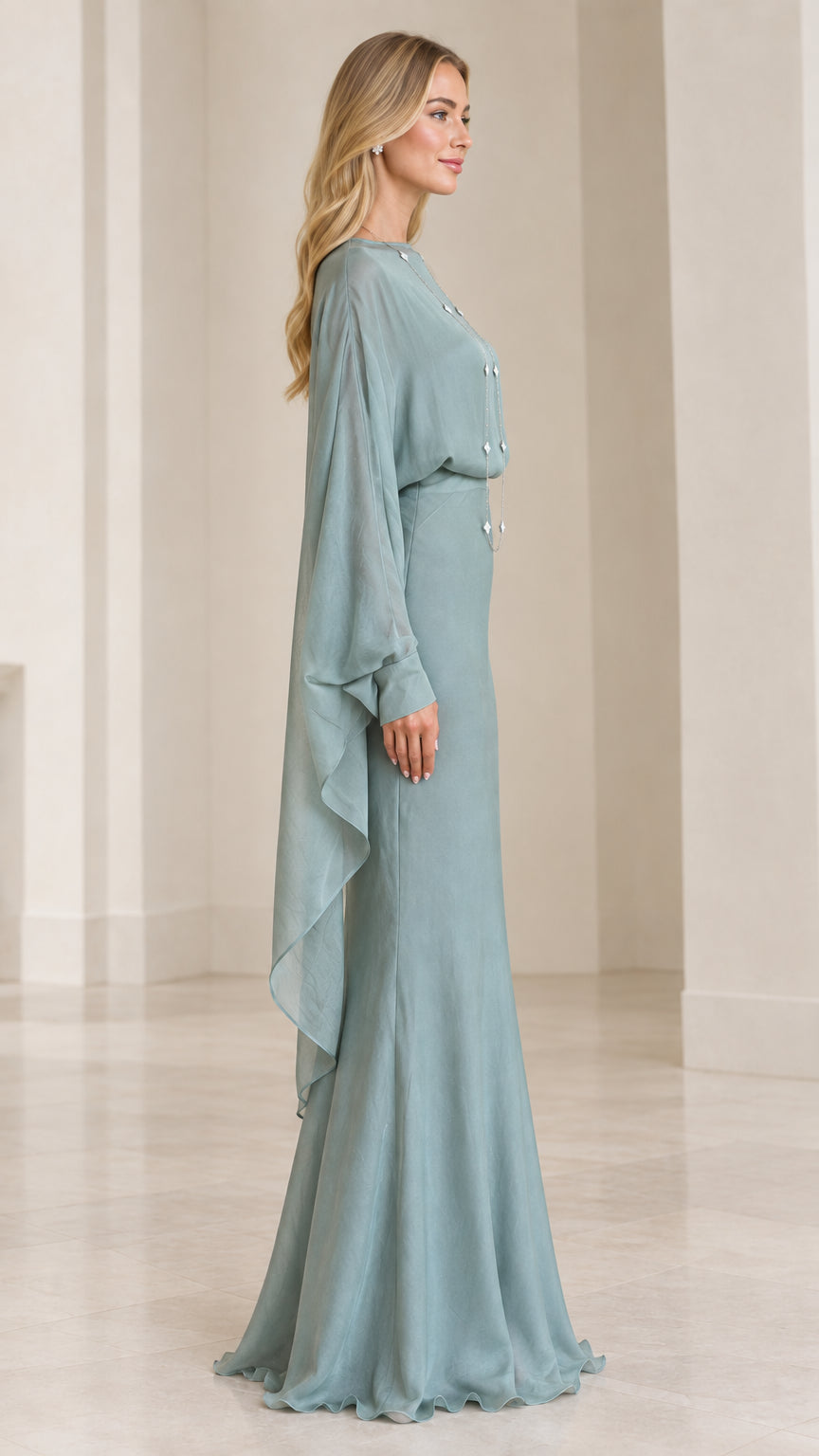 Side profile of model in sage green formal gown with long flowing cape sleeves