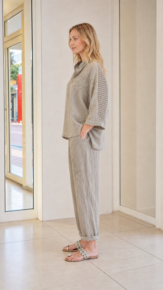 Side view of model wearing taupe two-piece set with sleeve detail