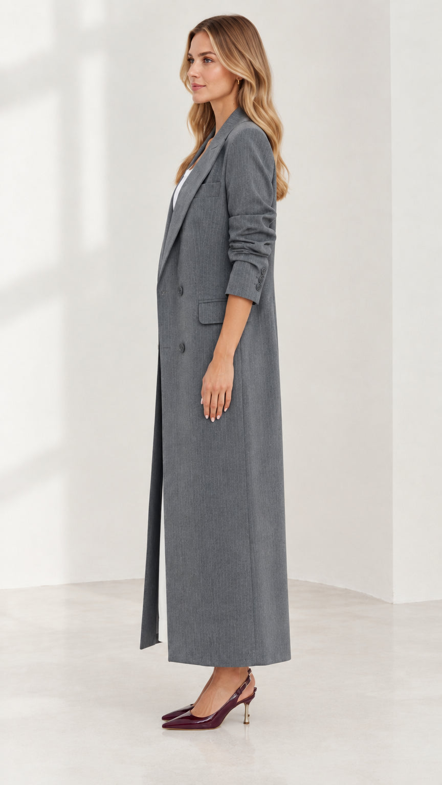 Side profile view of woman modeling longline grey double-breasted duster coat