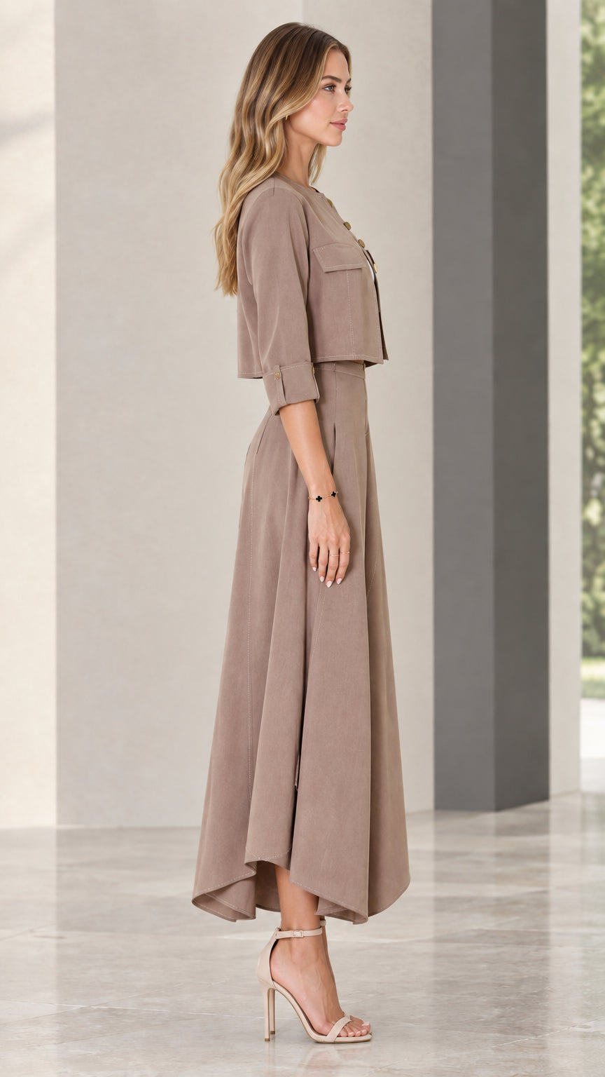 Side profile of model wearing taupe two-piece jacket and wide-leg trousers