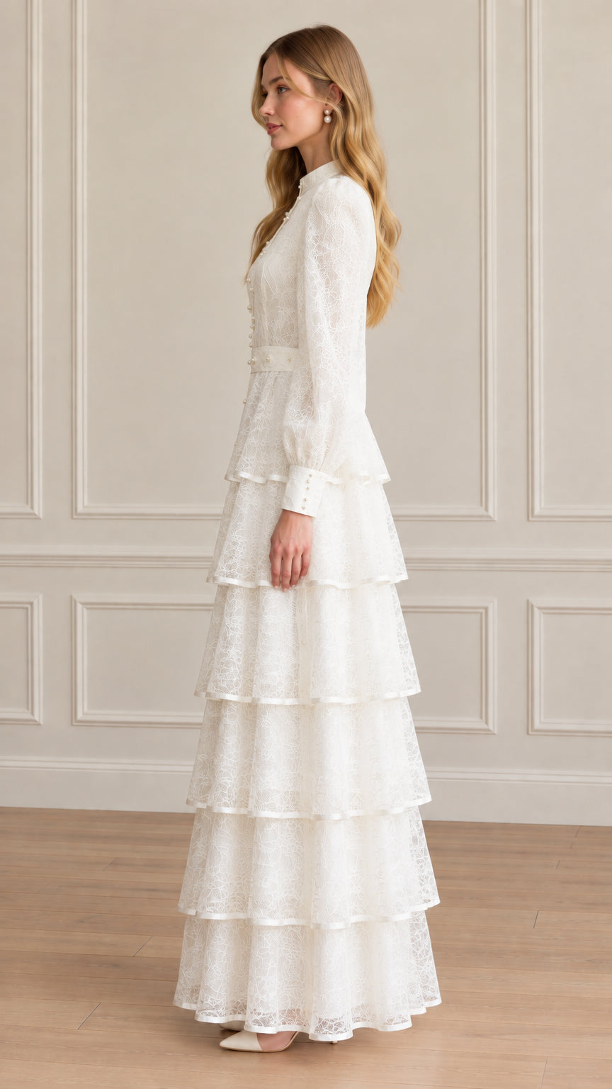 Side profile of woman in elegant long sleeve white lace tiered maxi gown