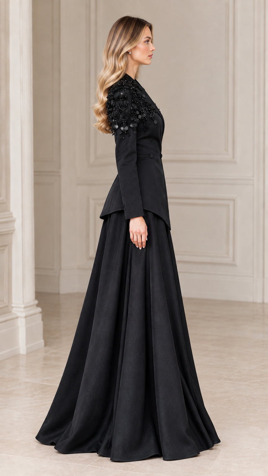 Side profile of model wearing black two-piece formal peplum blazer and floor-length skirt