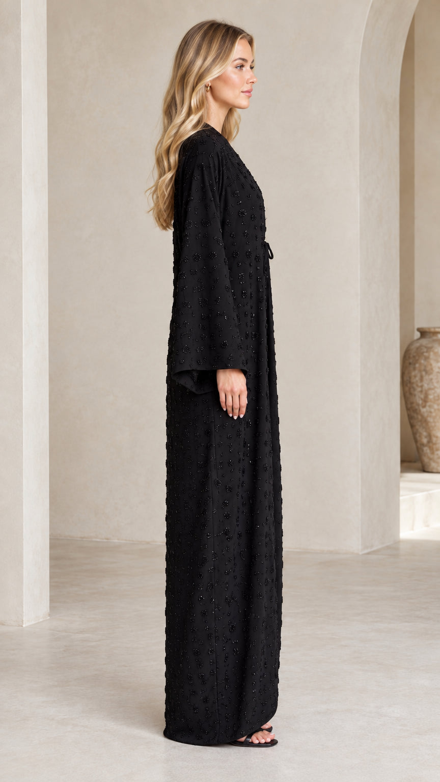 Side profile view of woman wearing Black full-length embellished kimono maxi dress