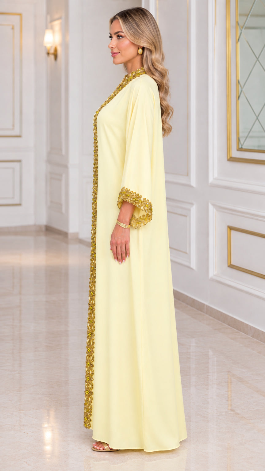 Side view of pale yellow long sleeve kaftan dress with embellished border