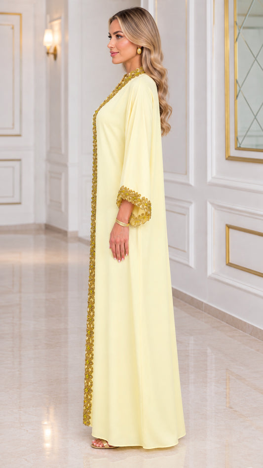 Side view of pale yellow long sleeve kaftan dress with embellished border