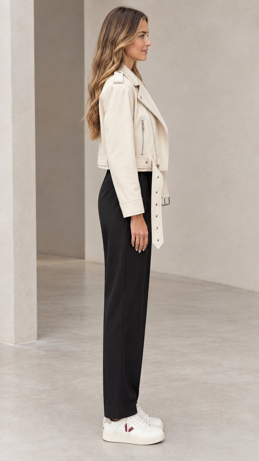 Side profile of woman wearing off-white cropped faux leather biker jacket