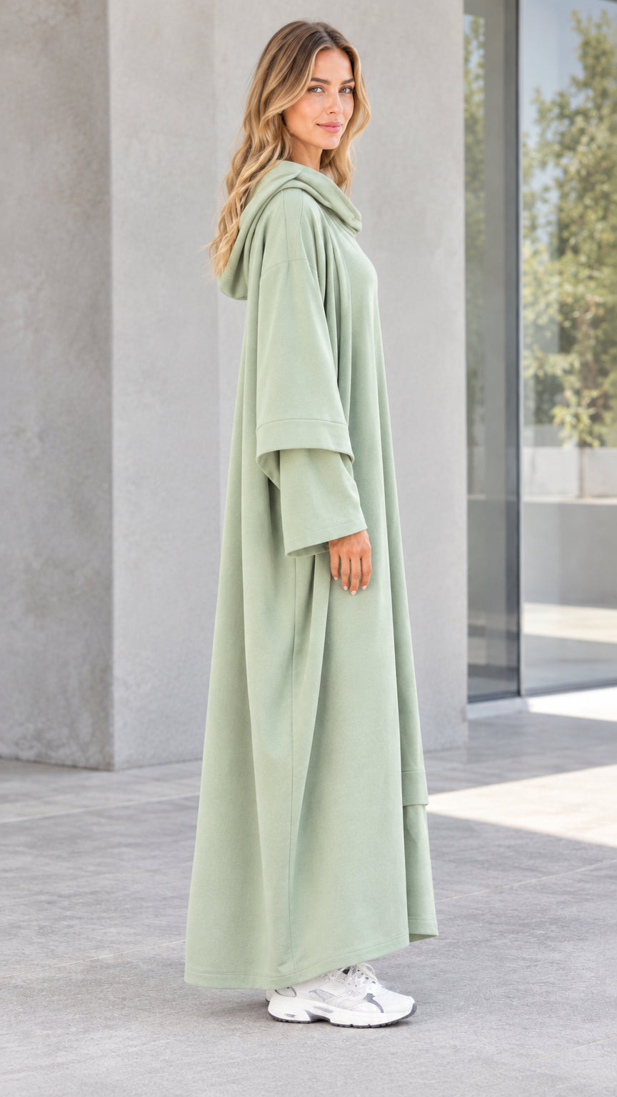 Side profile view of woman wearing long sleeve sage green hooded maxi dress