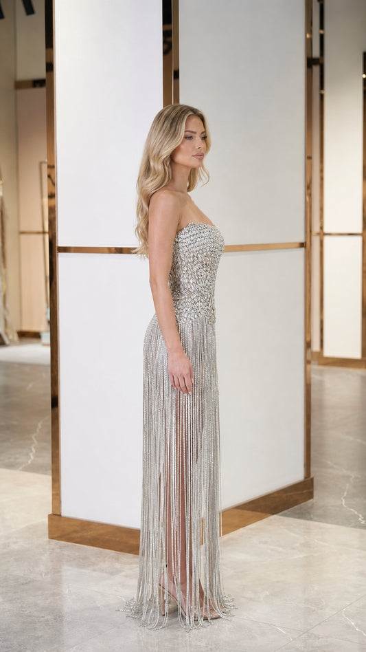 Side profile view of model in silver fringe evening gown