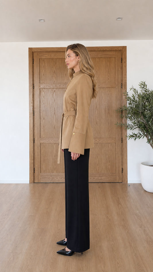 Side profile view of model in camel stand collar belted jacket