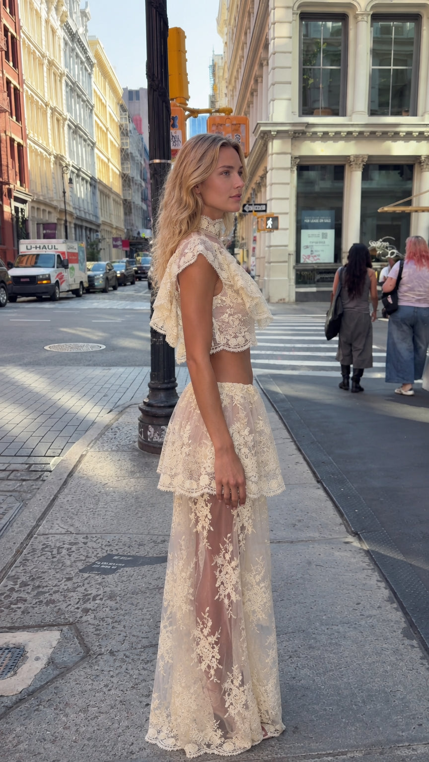 Side angle view of model wearing cream lace two-piece maxi skirt set