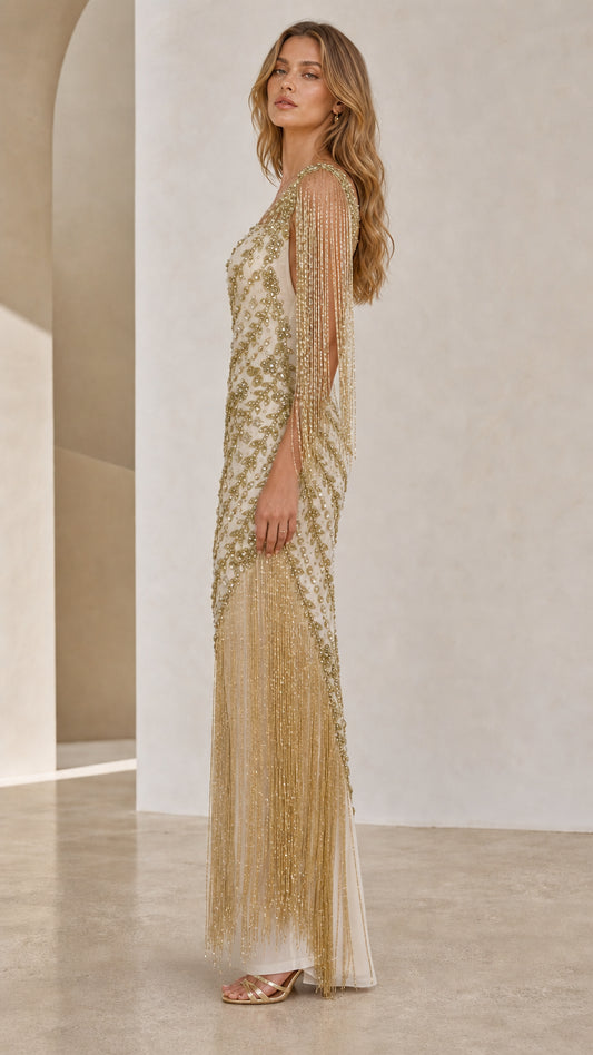 Side profile view of champagne beaded gown showing fringe detail