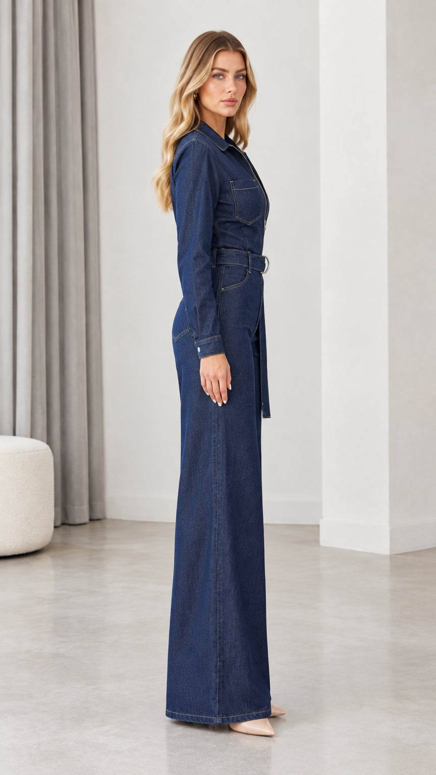 Side profile view of dark blue wide leg denim jumpsuit
