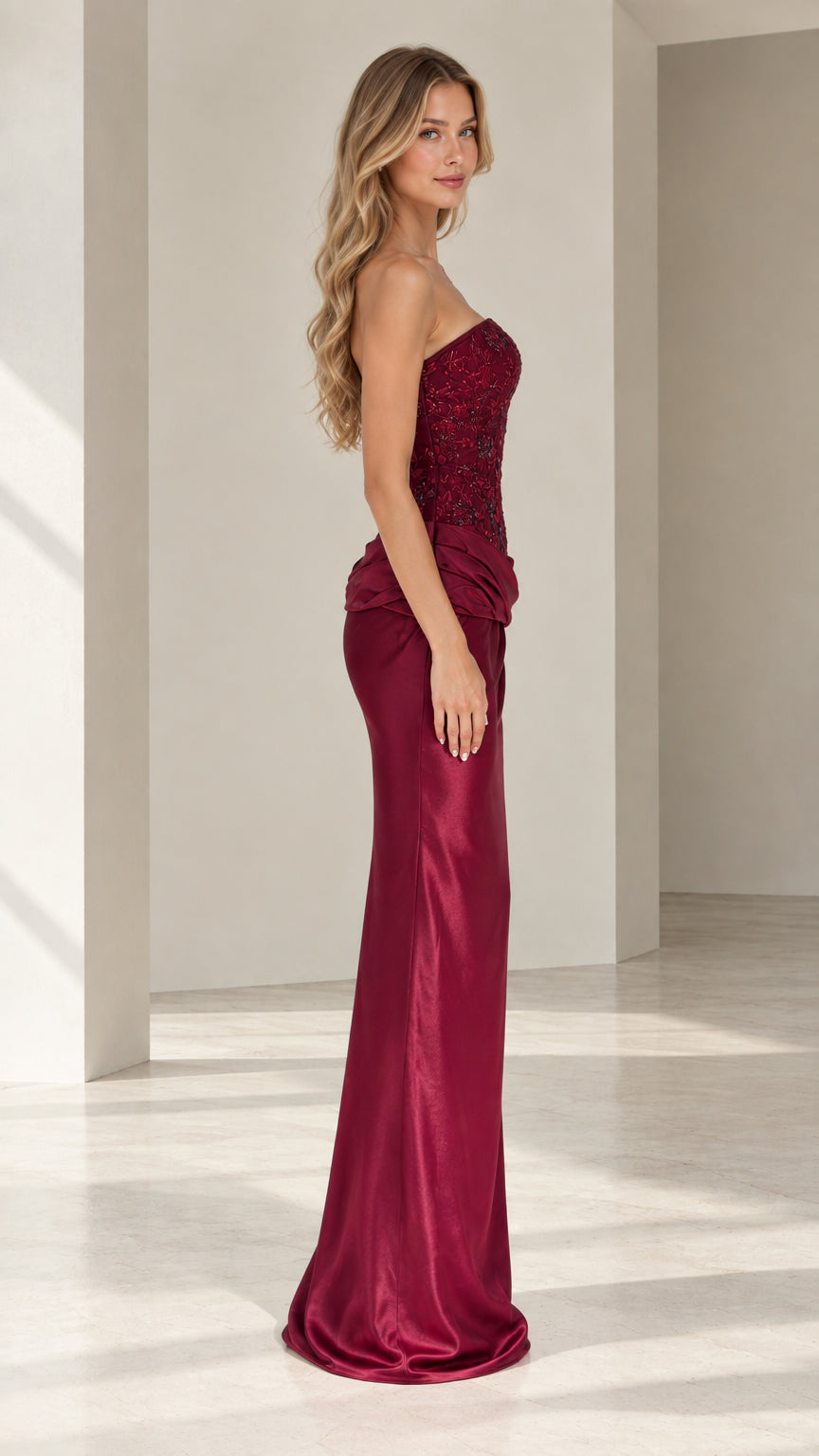 Side profile view of burgundy strapless embellished corset maxi dress