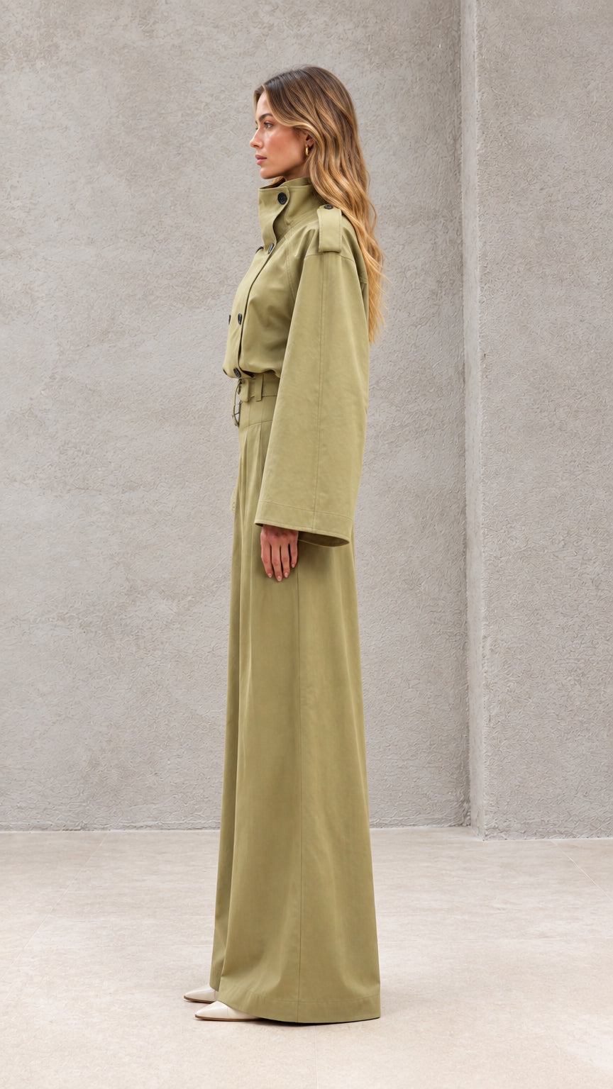Side profile view of model wearing sage green wide-leg jumpsuit with flared bell sleeves