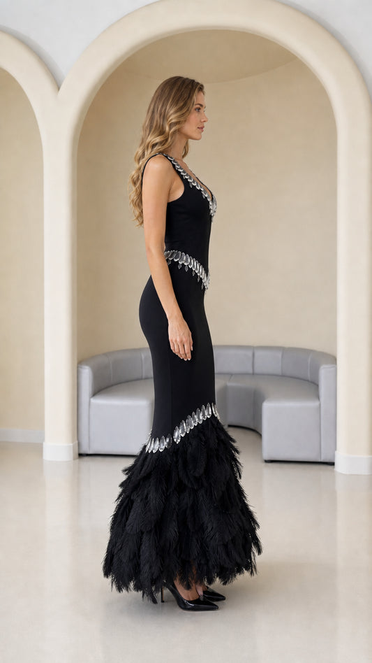 Side profile of black fitted evening gown with feather trumpet skirt