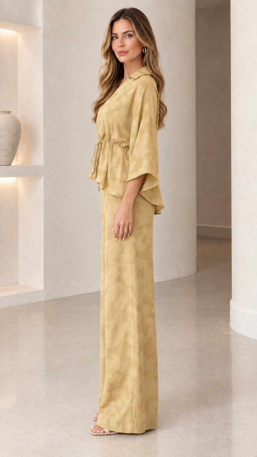Side profile of woman in mustard collared blouse and wide-leg trousers