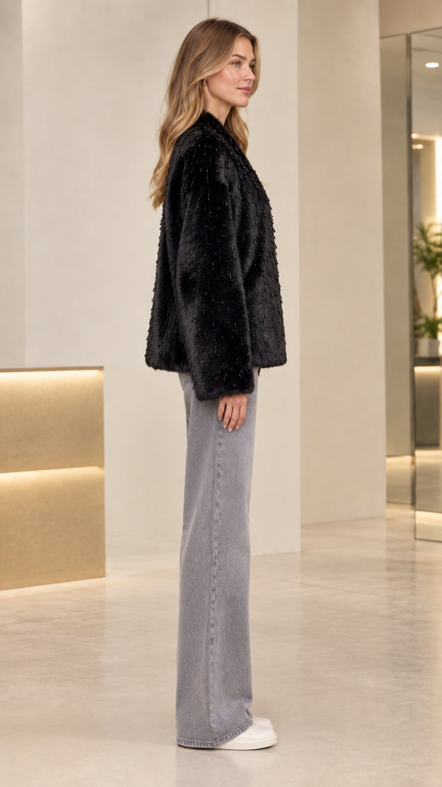Side profile of model wearing black textured faux fur jacket