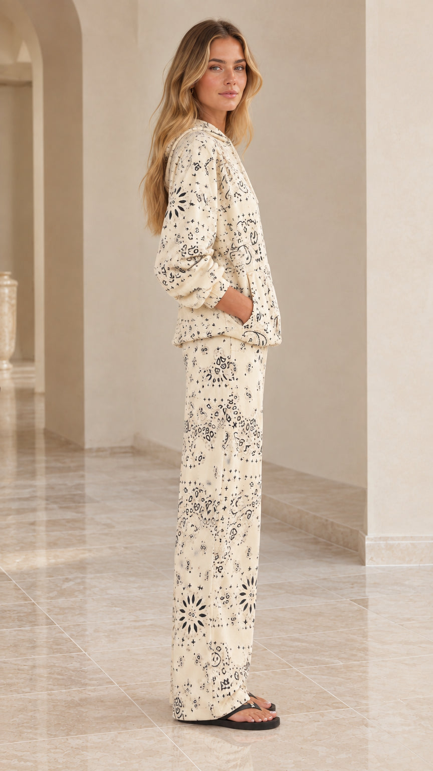 Side view of woman modeling cream paisley print two-piece lounge set